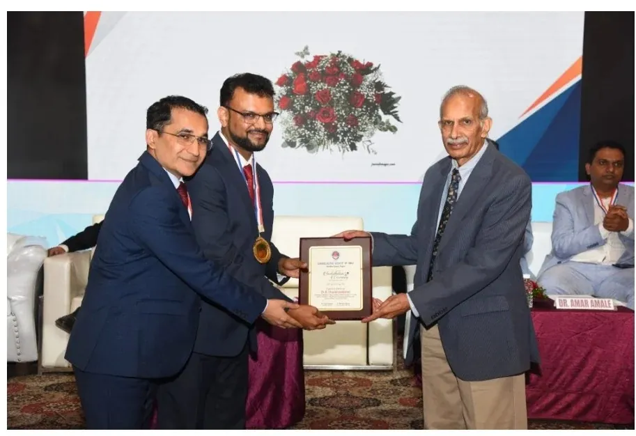 Dr. Pavan Agrawal receiving a memento from senior colleagues on stage