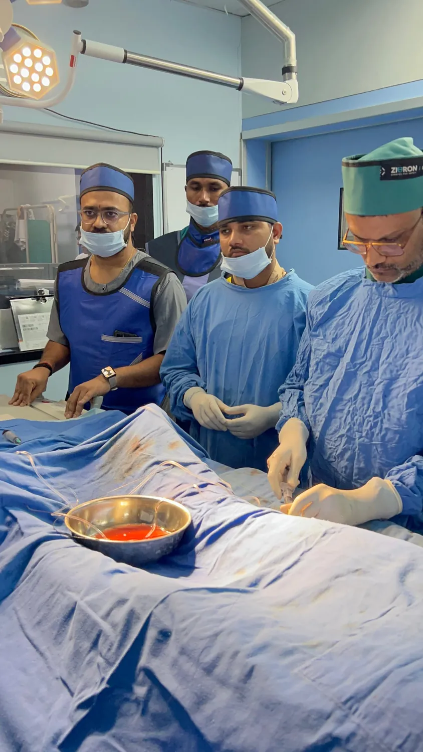 Interventional cardiology team in radiation-protection caps and aprons